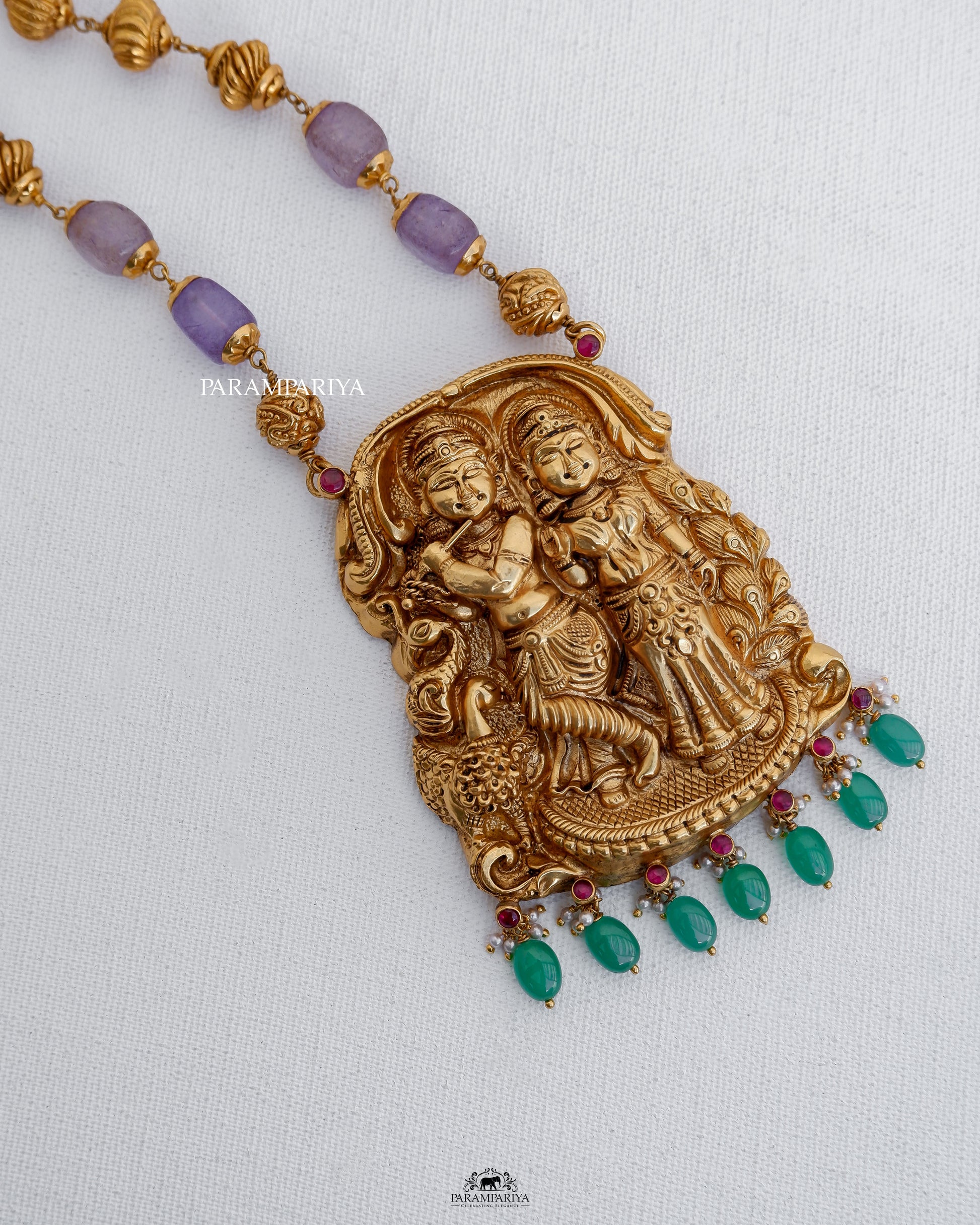 This handcrafted temple necklace showcases a depiction of Lord Krishna and Radhe, crafted with pure silver and enhanced with micron gold plating and semi-precious beads.